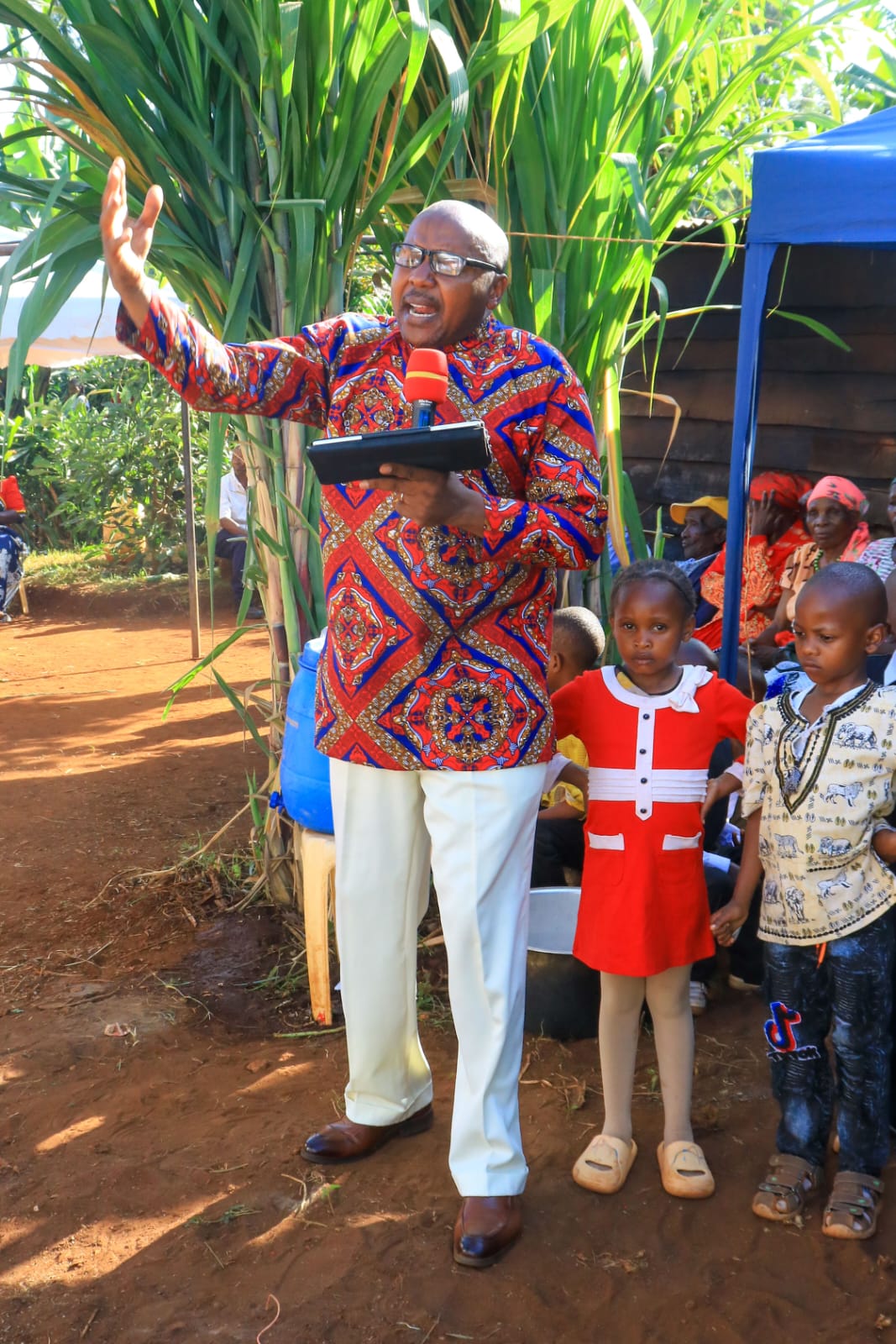 Bishop David Kibali preaching during an outdoor ceremony